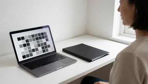 Portrait photographer choosing a background on a laptop in a white office with natural light and a black folder.