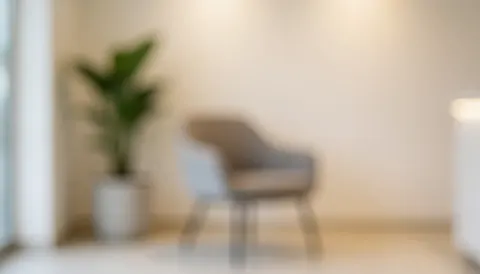 Modern reception area with a chair and plant in bokeh, creating a calm and professional atmosphere for text overlay.