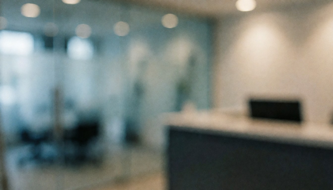 Blurred background of a glass storefront reception with glass partitions, desk, and warm lighting, ideal for text overlay.