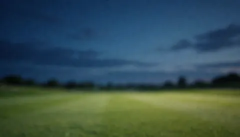 Soft sunset golf course background with dark blue sky and gentle clouds, ideal for golf service text overlays