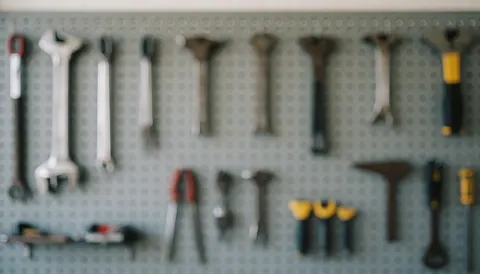 Blurred background of repair tools hanging on a gray wall board, suitable for heating repair services.