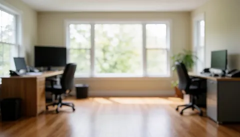 Bright, empty office space featuring polished hardwood floors, large windows, and vacant desks, ideal for professional cleaning services.