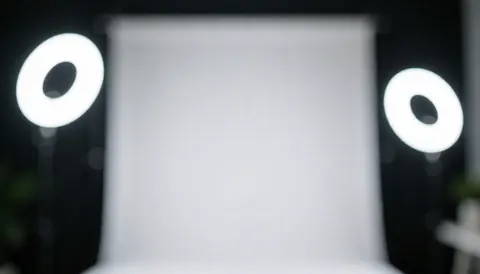 White background with two bright ring lights in a dark studio, ideal for eyebrow lamination service text overlays