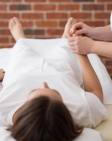 Close-up of reflexology treatment on a client's foot during a wellness session