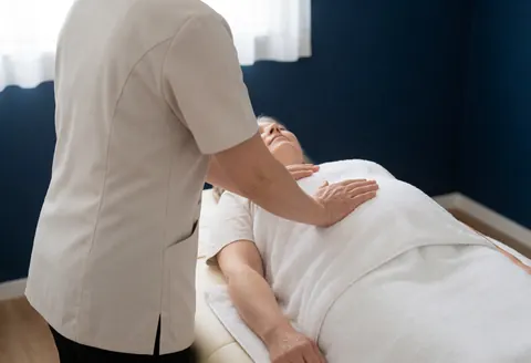 A professional massage therapist applying a gentle massage to a pregnant woman lying on a table in a serene spa setting.