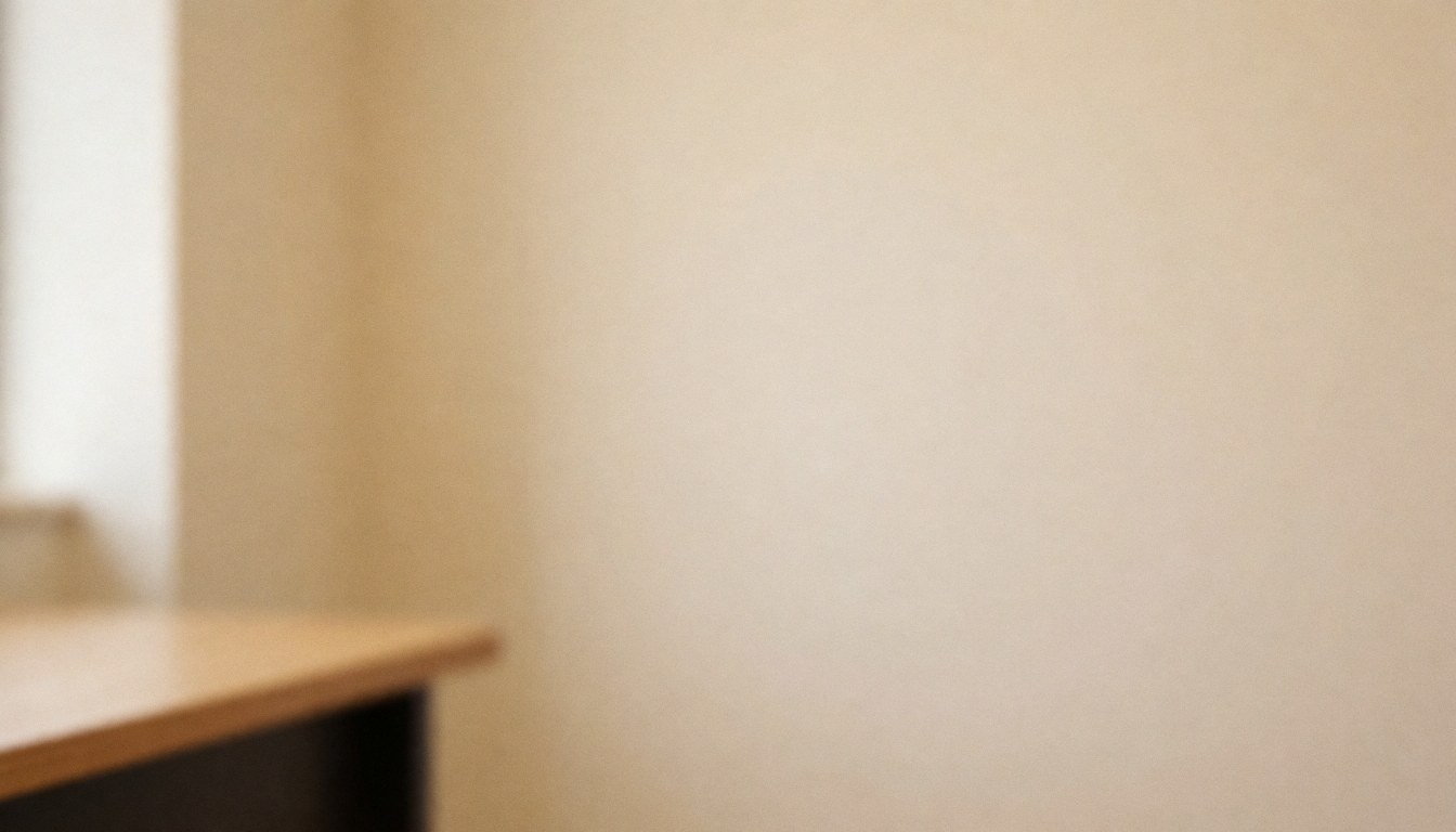 Serene beige wall background with a wooden desk edge, ideal for language school text overlays and educational content.