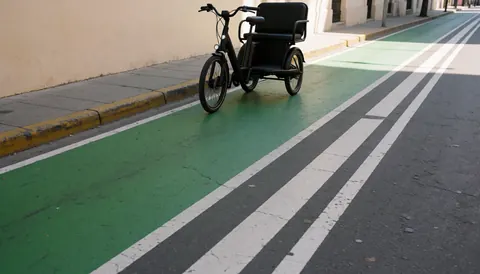 A green painted bicycle path with clear white lane markings on asphalt pavement.
