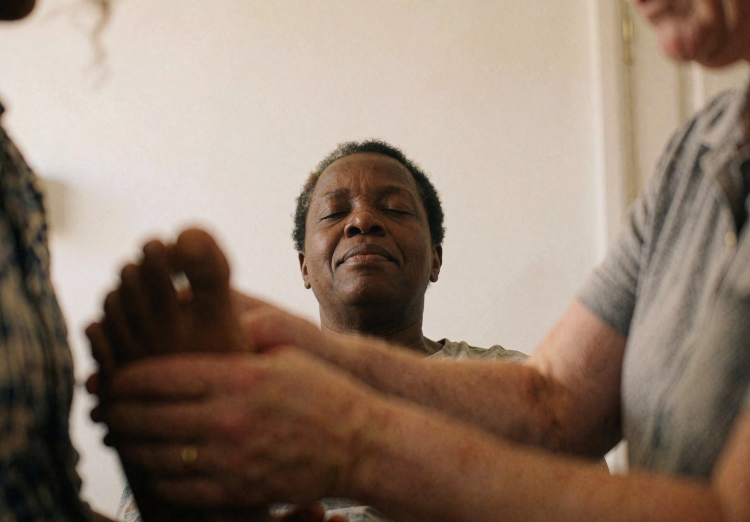 Close-up of reflexologist hands massaging a client's foot during a professional therapy session.