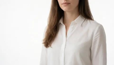 Profile view of a woman with brown hair wearing a white shirt on a plain white background, suitable for business website headers