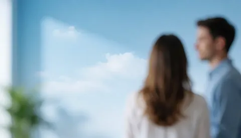 View of a blue sky with clouds through an office window, providing a clean and professional background suitable for business text overlays.