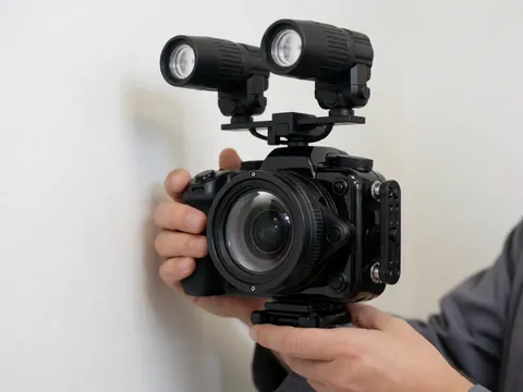 Professional underwater camera equipped with external strobes, held by a photographer against a white background for marine documentation