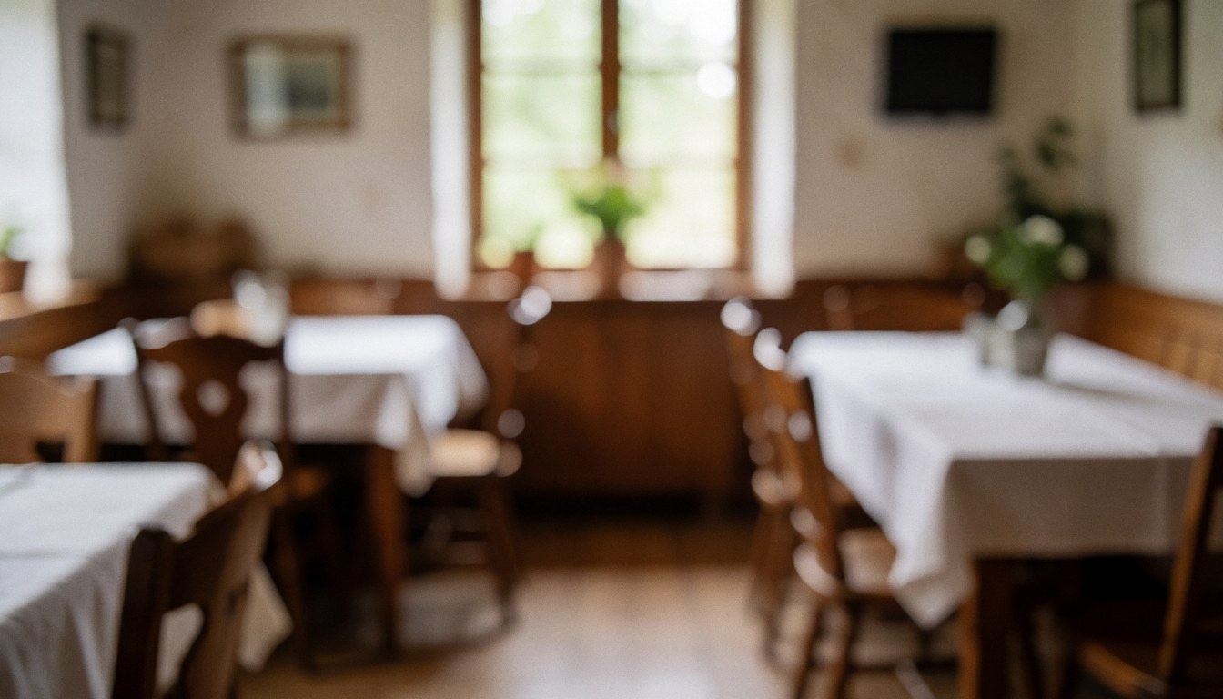 Interior of a rural restaurant with white tablecloths, wooden chairs, and natural light from the window, suitable for text background.