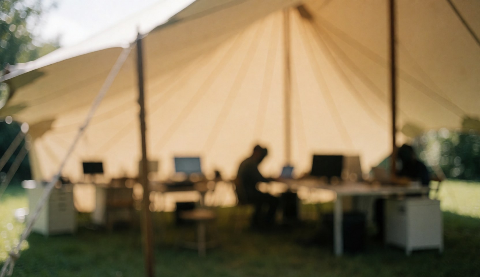 Beige canopy tent covering work tables, ideal for text background in outdoor events