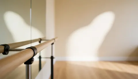Wooden ballet barre in a dance studio with beige walls, light wood floor, natural light, and mirror, ideal for text