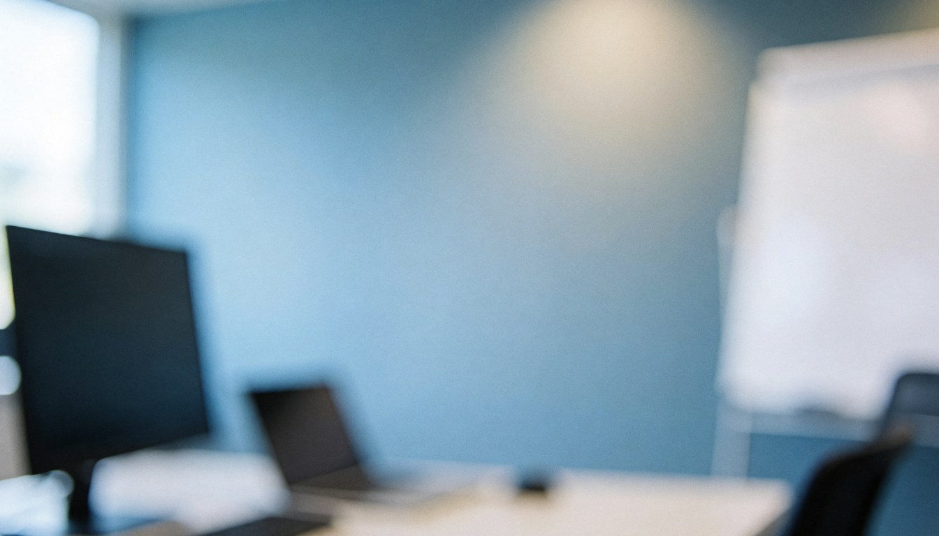 Professional office background featuring computer monitors and a whiteboard against a blue wall with soft lighting, suitable for text overlay