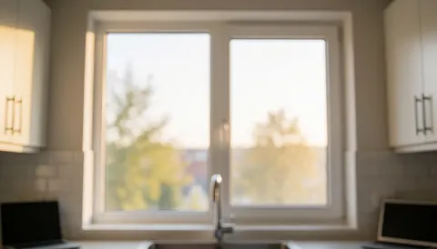 Modern kitchen background featuring a newly installed glass window with a white frame and warm lighting, suitable for window repair services.