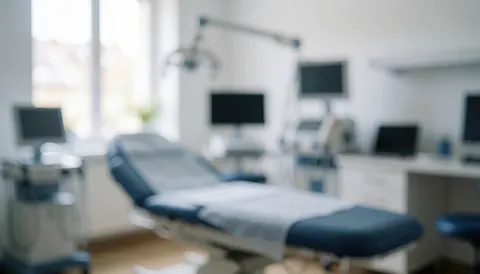Abstract background of a medical room with a treatment bed, monitors, and equipment, ideal for dermatological service texts or logos.