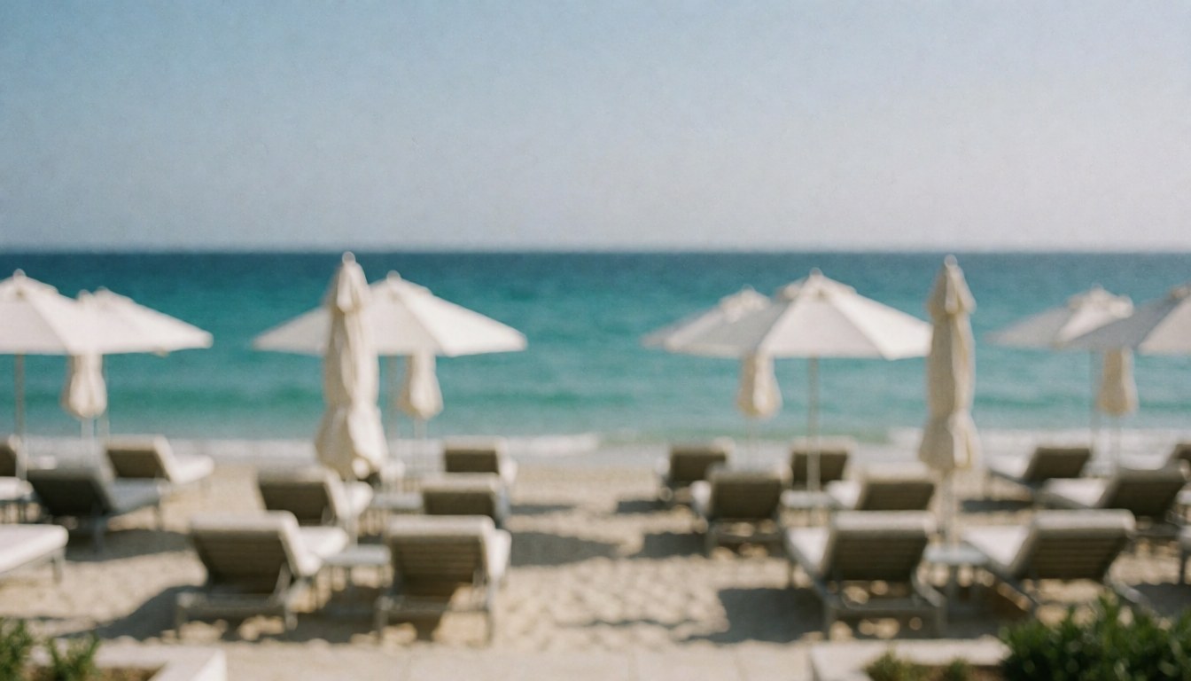 Beach background with chairs and umbrellas, ideal for text, featuring turquoise water and light sand.
