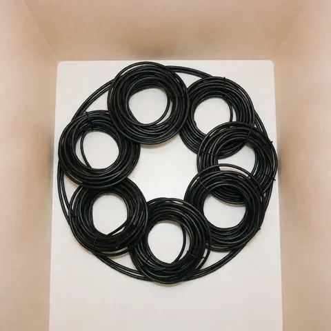 Coiled black HDMI cables on a white surface, ideal for television repair products with soft beige walls and even lighting.