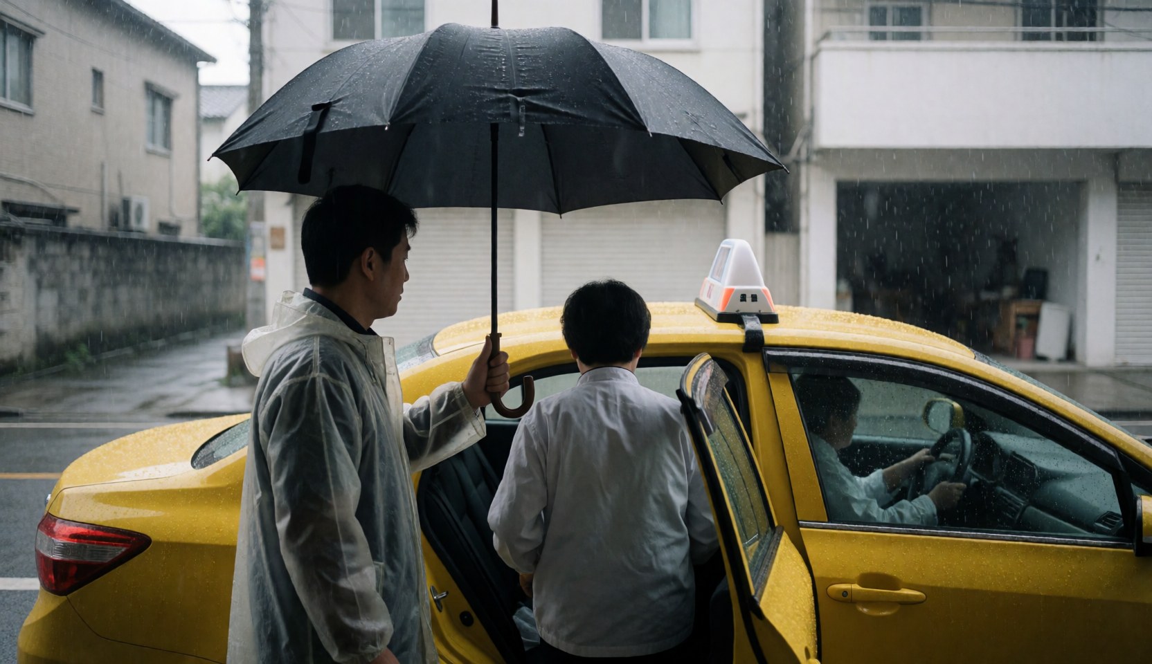 A taxi driver holds a black umbrella to shield a passenger entering a yellow taxi on a wet street during heavy rain.