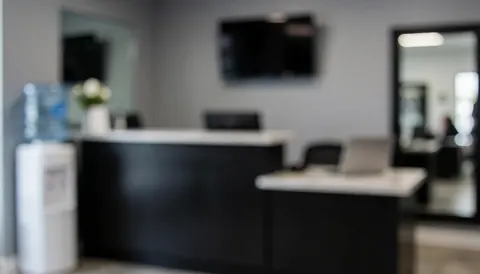 Empty gym reception desk with a large mirror and water bottle, suitable for text overlay