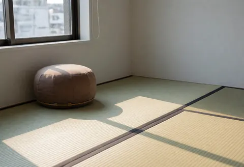 A shiatsu zafu cushion placed on a tatami mat near a window, creating a calm and professional atmosphere for therapy sessions.