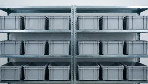 Industrial metal shelving units holding neatly arranged gray plastic boxes against a clean white background, suitable for text overlay on television repair services.