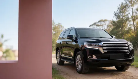 Modern black SUV parked on a dirt road next to a pink wall, suitable for vehicle sales website hero image