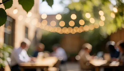 Bokeh background of a patio with warm lights, green leaves, and tables, ideal for Spanish class text overlay.