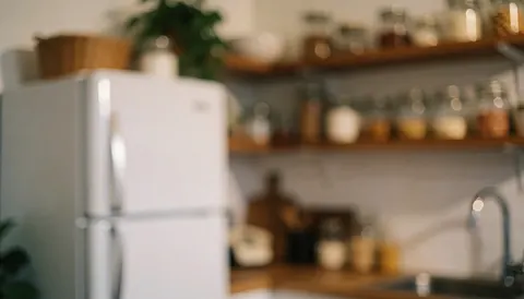 Kitchen background featuring a white refrigerator and wooden shelves with glass bottles, illuminated by warm light for food preparation text overlays