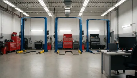 Interior of an auto repair garage featuring three blue vehicle lifts, red toolboxes, and a polished concrete floor suitable for text overlay.