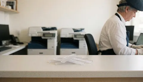 Plastic binding combs arranged on a clean office counter with photocopiers in the background for copy center services