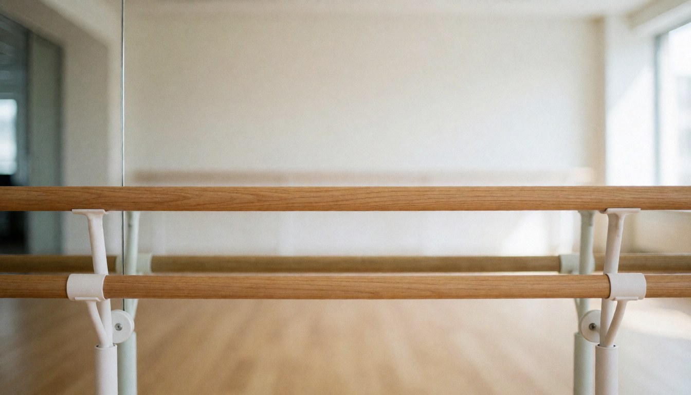 Wooden ballet barre in a dance studio with mirrors and light floor, professional background for text.