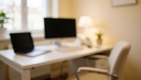 Bright consultation room featuring a white desk, computer monitor, chair, and natural light, suitable for acne treatment services