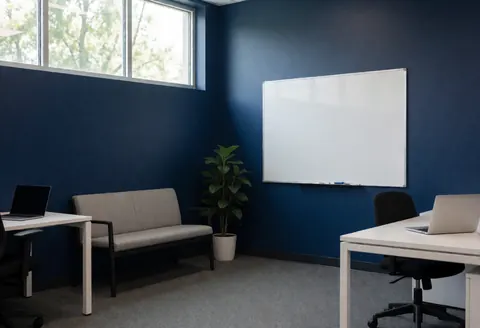 Empty training room featuring a whiteboard, bench, potted plant, and dark blue wall, suitable for tennis classes