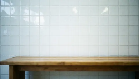 Visible wood grain on a wooden bench set against a bright white tiled wall, serving as a clean background for text in a water park setting