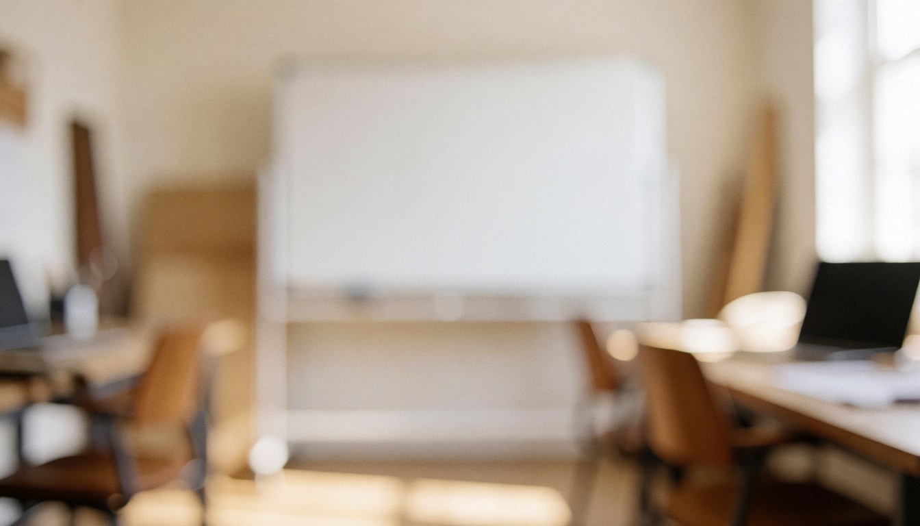 Soft focus background of a writing workshop featuring a whiteboard, wooden tables, and chairs illuminated by warm diffused light, suitable for text overlay.
