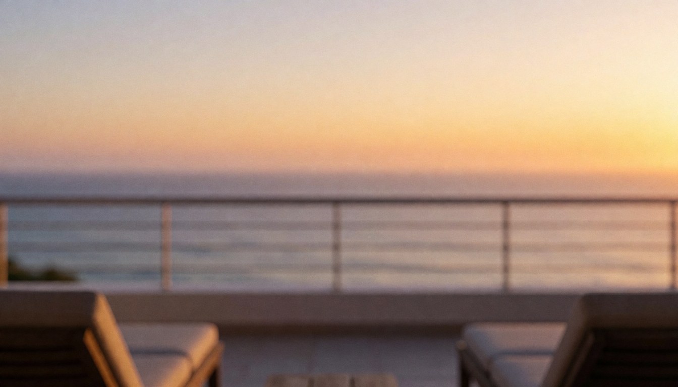 Terrace with beach chairs overlooking the ocean at sunset, featuring golden light and an orange and purple gradient background ideal for text overlay