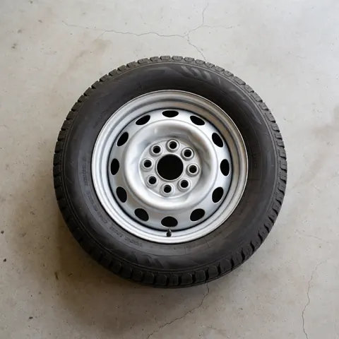 Top view of a spare tire resting on cracked concrete, suitable for towing service products
