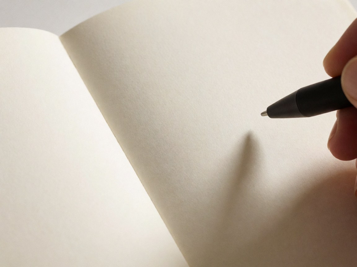 A black pen resting on textured paper, highlighting surface details and warm lighting for product photography.