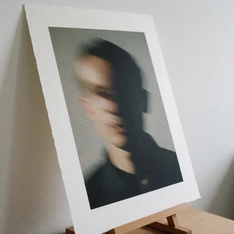 Artistic photograph with shadow effect printed on textured paper and supported by a wooden stand
