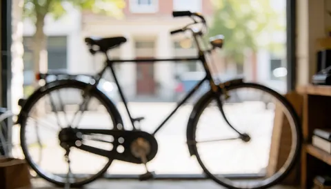 Vintage bicycle inside a workshop display case with natural light and bokeh background for text overlay