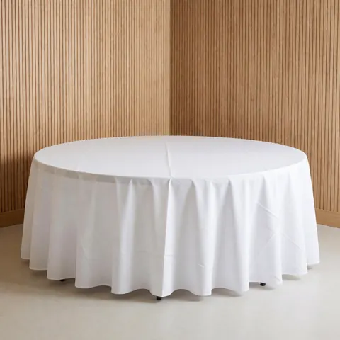 Round table covered with a white tablecloth on a light floor with wooden slat walls, suitable for event furniture rental