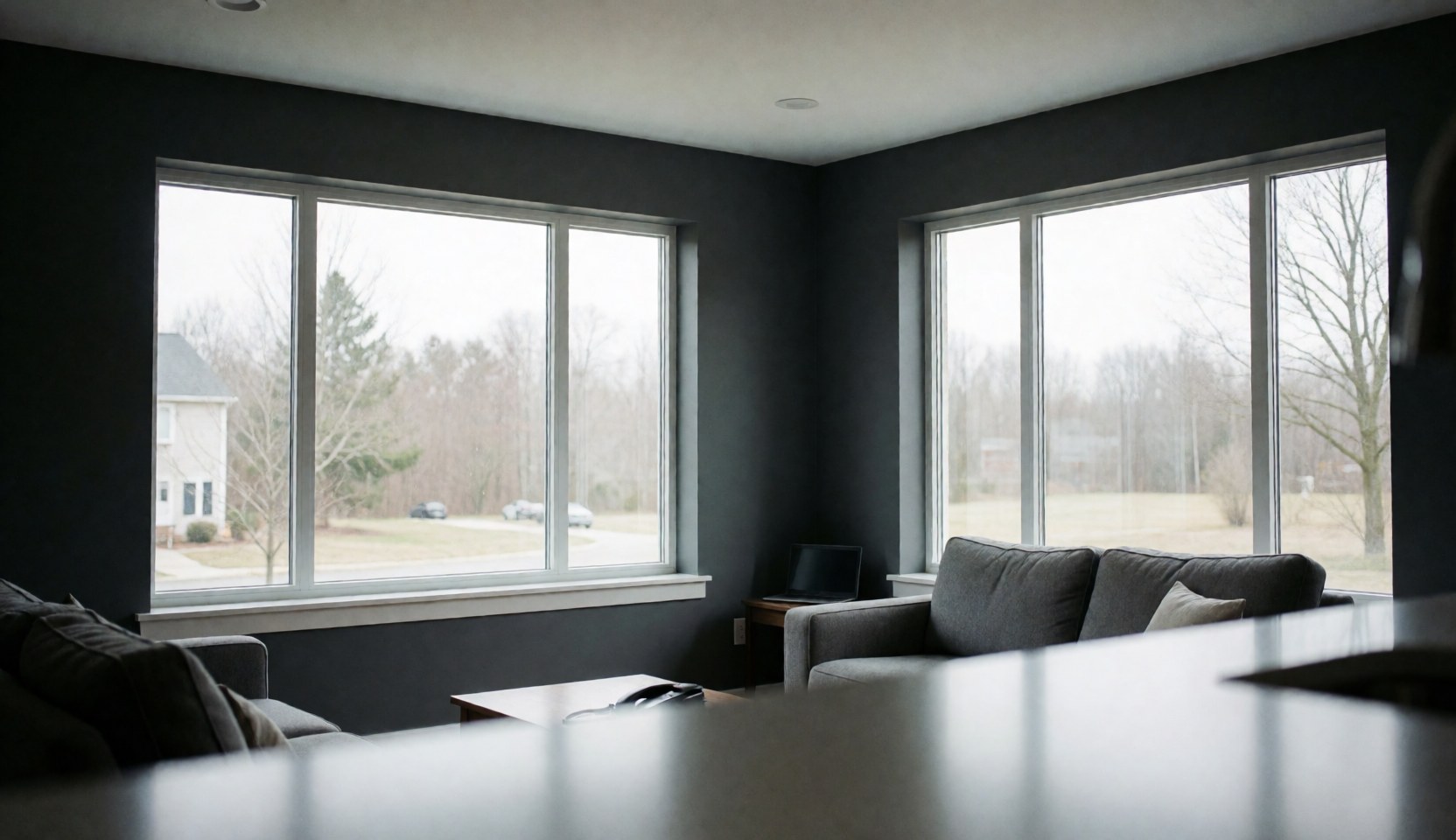 Bright living room with gray walls and large low-e windows, natural light, empty blurred space for text, ideal for window installation business
