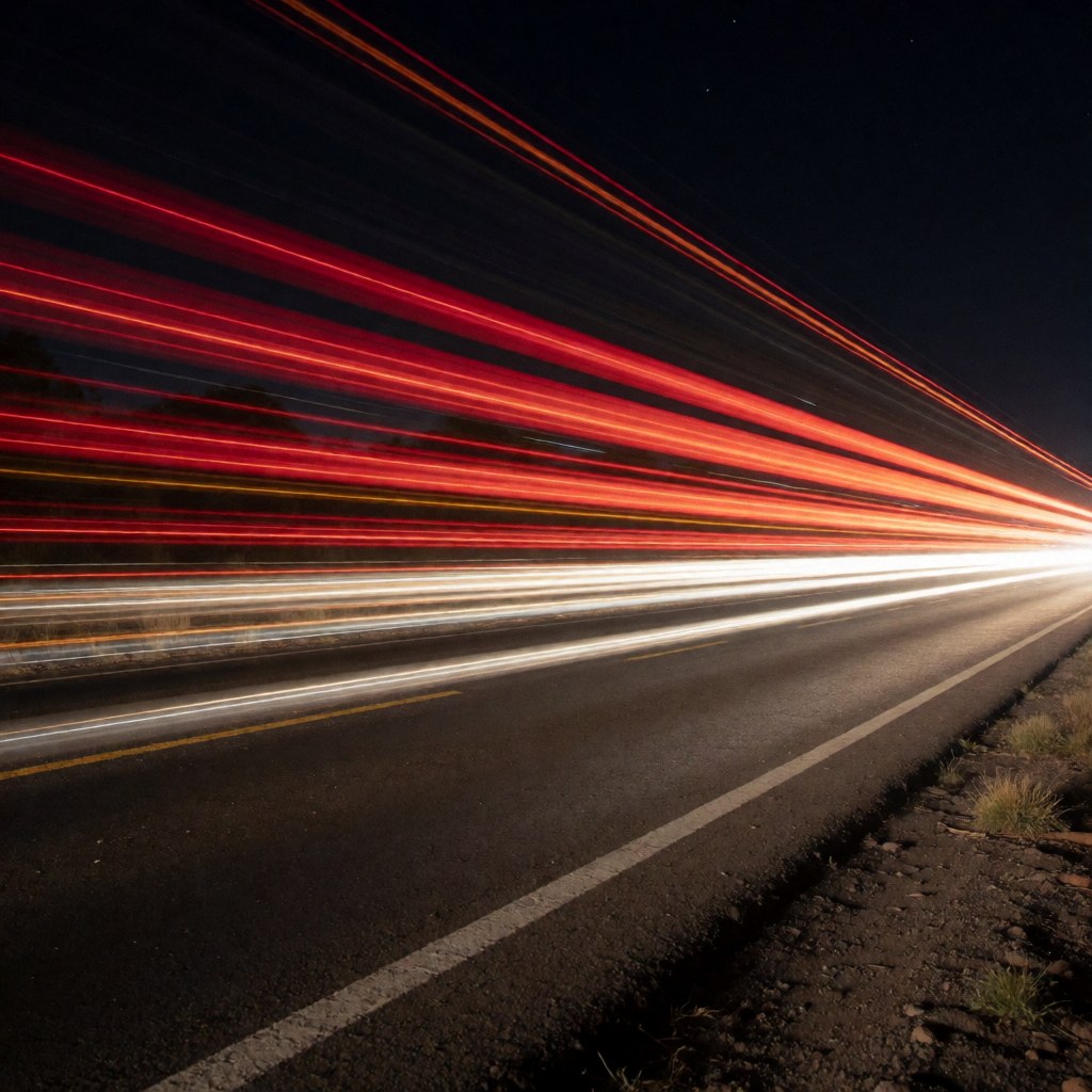 Long exposure photo showing red and white light trails from moving vehicles on a dark road, suitable for artistic photography business backgrounds.