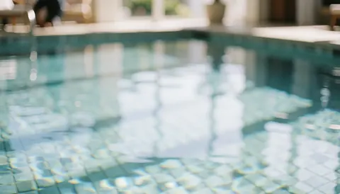 Blurred pool background with tiles and light reflections, ideal for beach service texts and aquatic experiences
