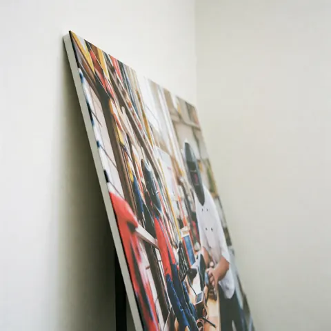 An acrylic sign featuring vibrant graphics mounted on a stand, showcasing high-quality graphic printing in a professional setting with white walls and even lighting.