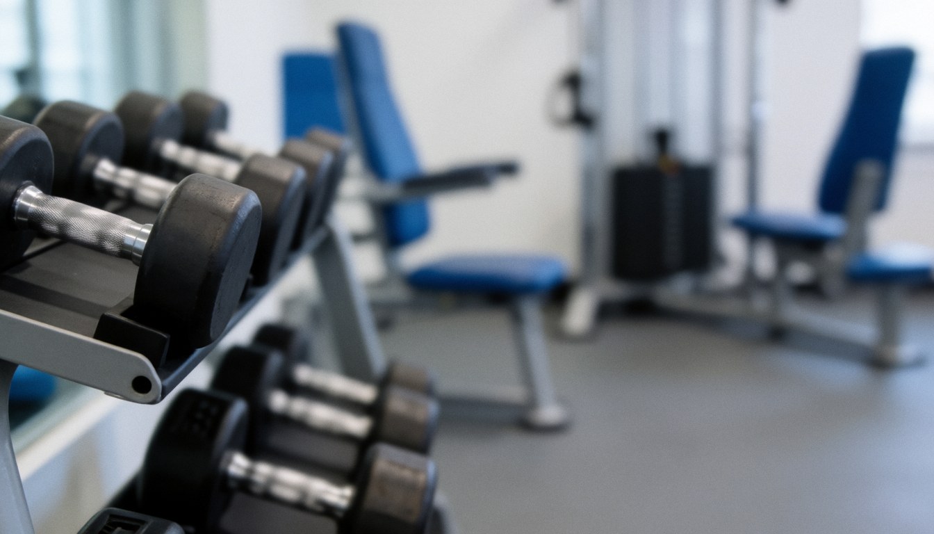 A neutral background featuring dumbbells and gym training machines, suitable for text overlays about physical preparation and recovery.