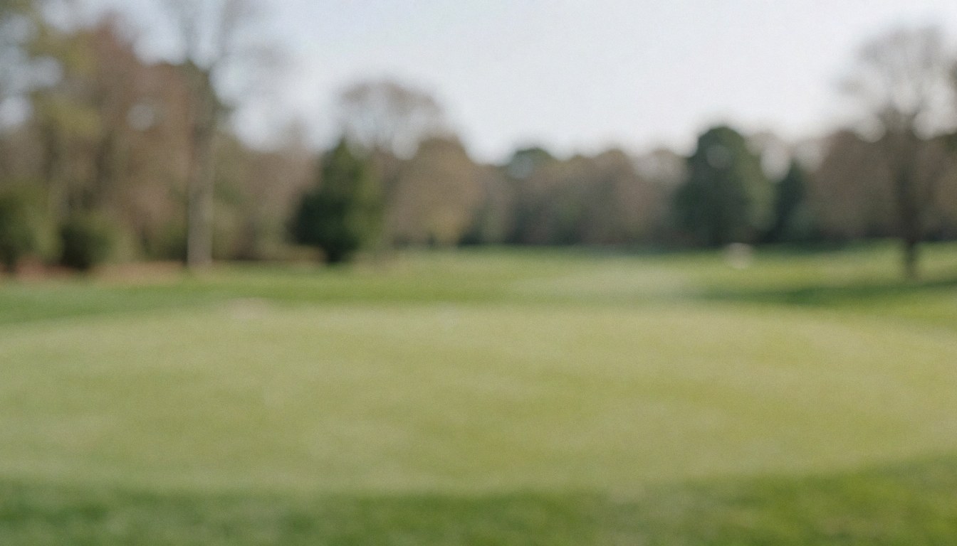 Out of focus golf course background with green grass and distant trees, ideal for overlaying advertising text.