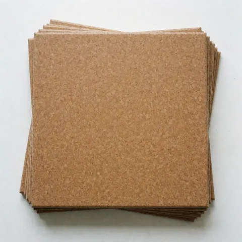 Square cork tiles with natural texture stacked on a white background for flooring installation
